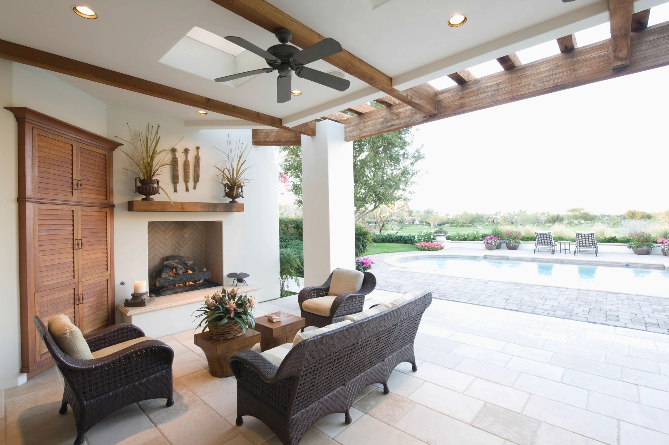 Outdoor luxury home backyard pation with gas wood-burning fireplace and seating area